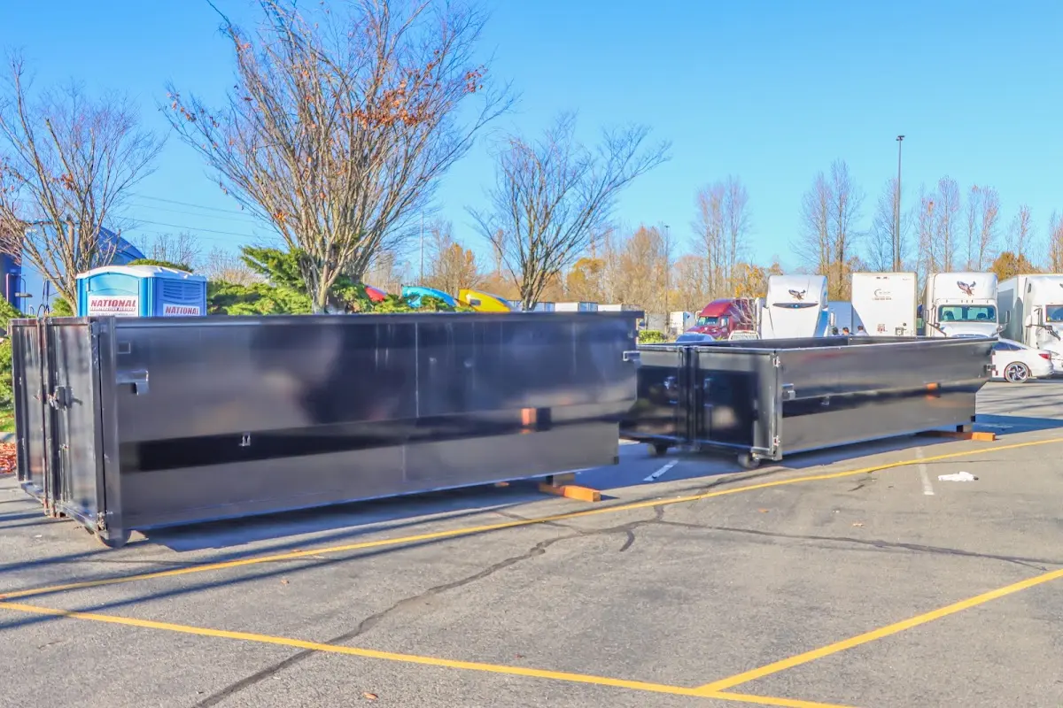 Professional dumpster rental service with roll-off container on residential driveway in Mercedes